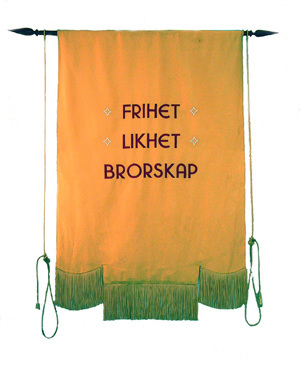 Baksiden av fanen til Eydehavn Elektrokjemiske Arbeiderforening, oransje med teksten "Frihet, likhet, brorskap"